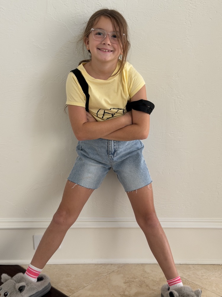 Selene smiling with her arms crossed, wearing a yellow t-shirt